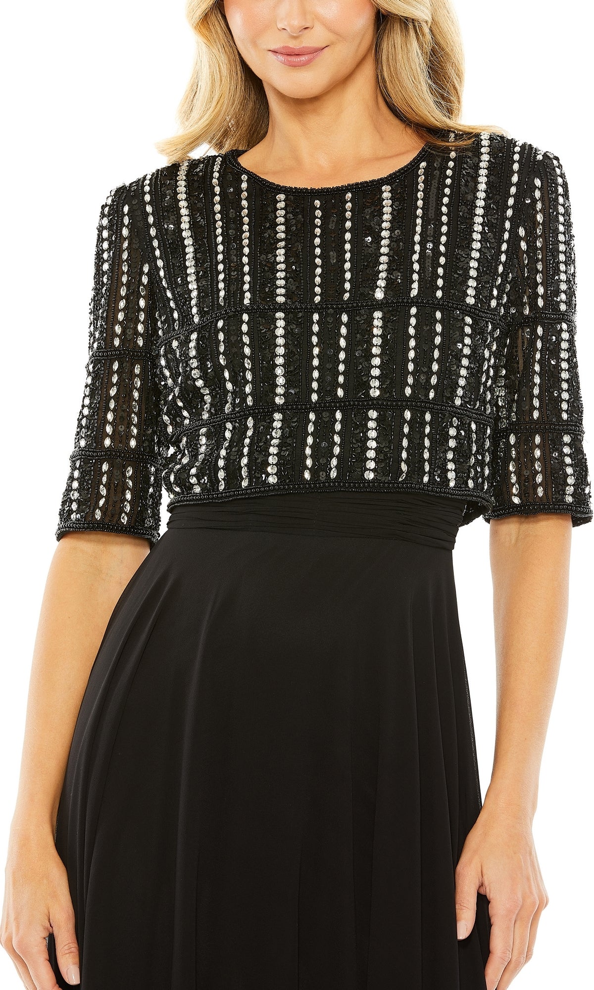 A woman models the Mac Duggal 9180, a short sleeve long formal dress featuring a black gown with a beaded geometric sequin pattern on the bodice.